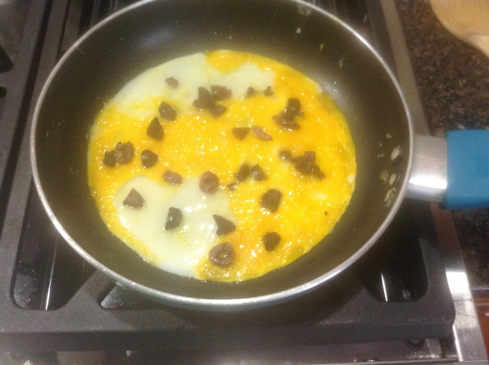 Drizzle the olives over the eggs and cook for one more minute.