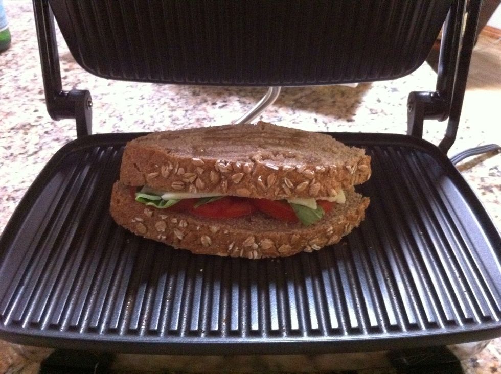 Drizzle the top of the sandwich with oil. Flip to place that side down on panini grill, or in a nonstick skillet. Drizzle oil on top and press, or flatten with another skillet until cheese melts.