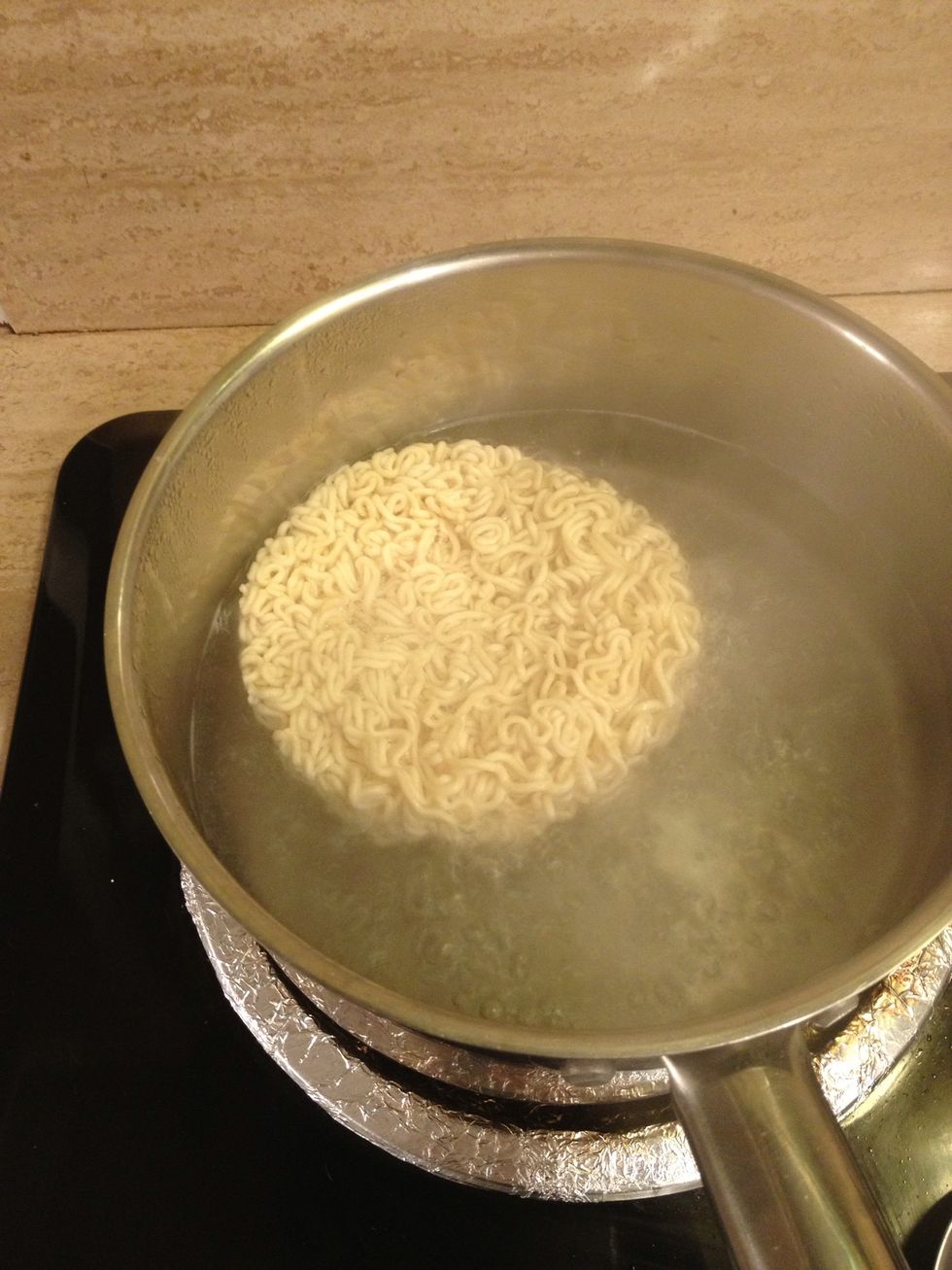 Drop in your instant ramen. You will only let them cook for about 2 minutes because they will continue to cook when you add to the wok later.