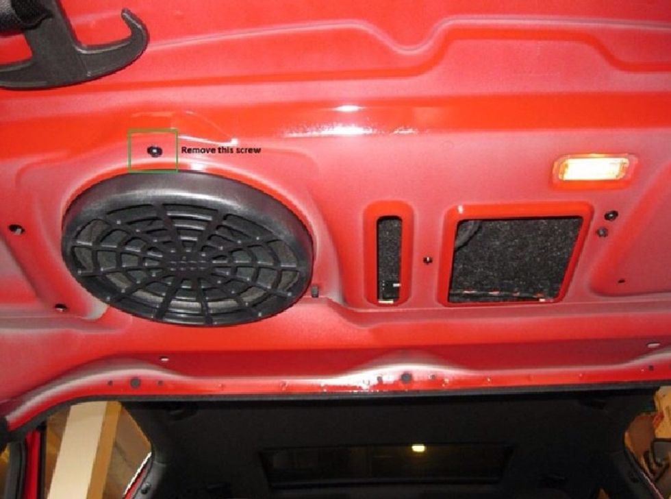 Drop the back seats down. You'll need to do this for easy access and to get at the rear deck cover lip.  Remove the Torx screw from the bottom of the stock sub, accessible from the trunk.