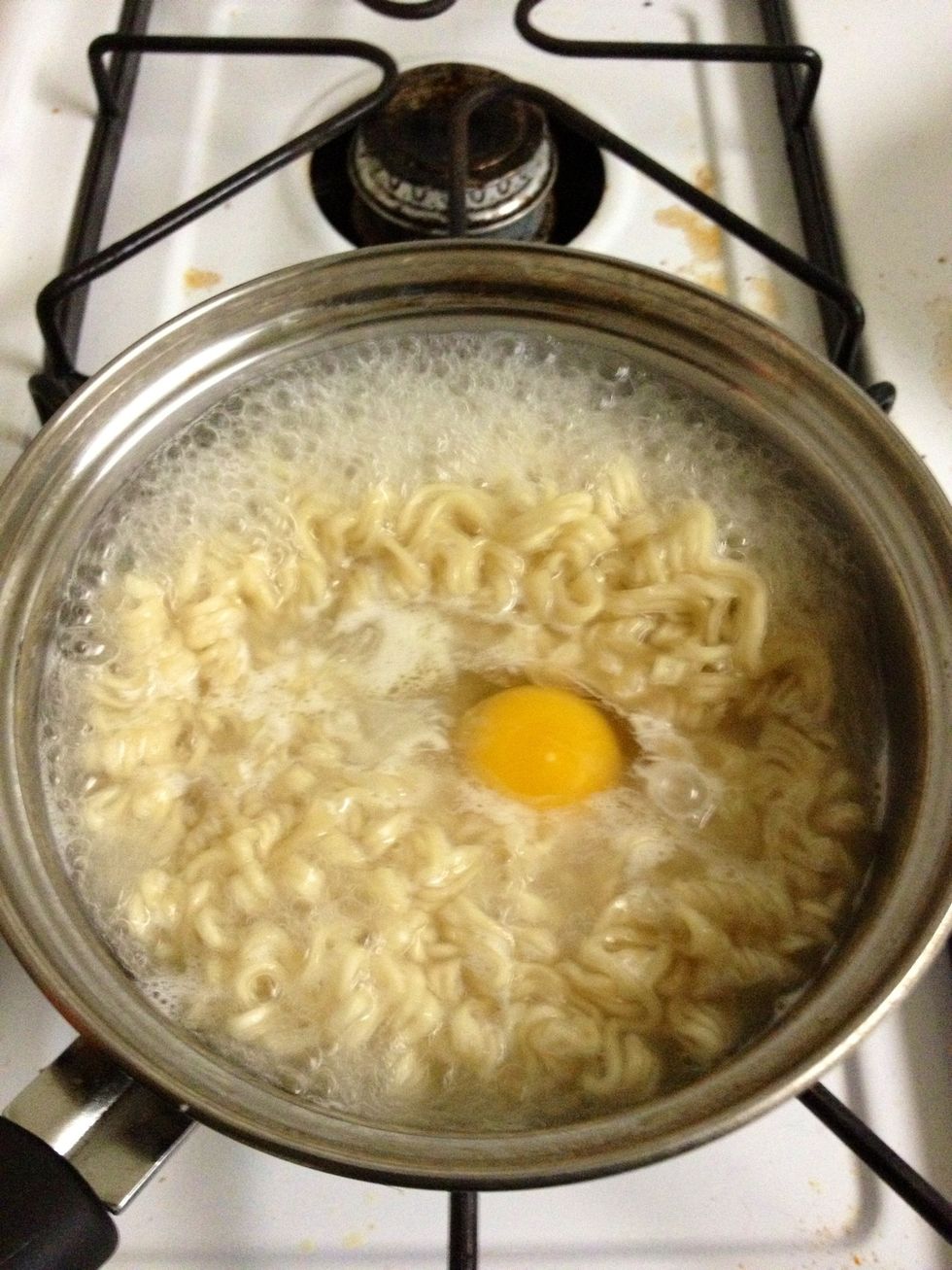 Drop the egg into the boiling broth, I don't like to scramble the egg just so I can have whole pieces of poached egg.
