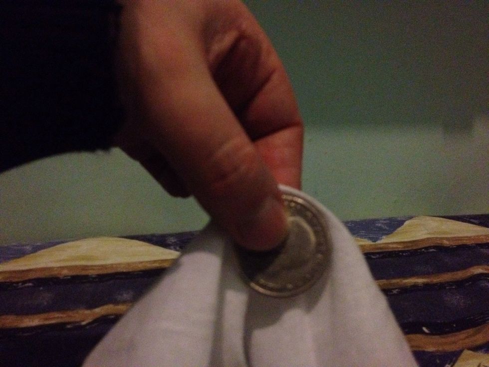 Drop the front and rear of the handkerchief over the top and turn your hand so your fingers are pointing down. The coin should be position as shown from your point of view.