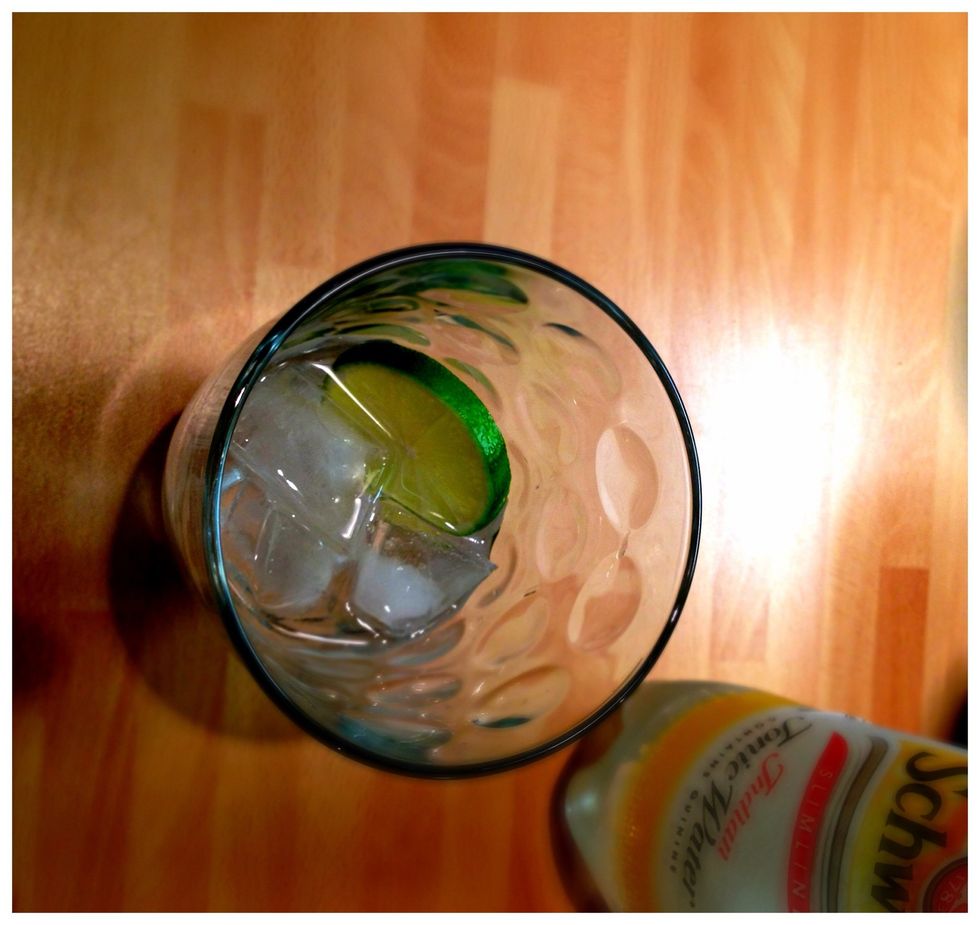 Drop the lime wheel into the gin and ice