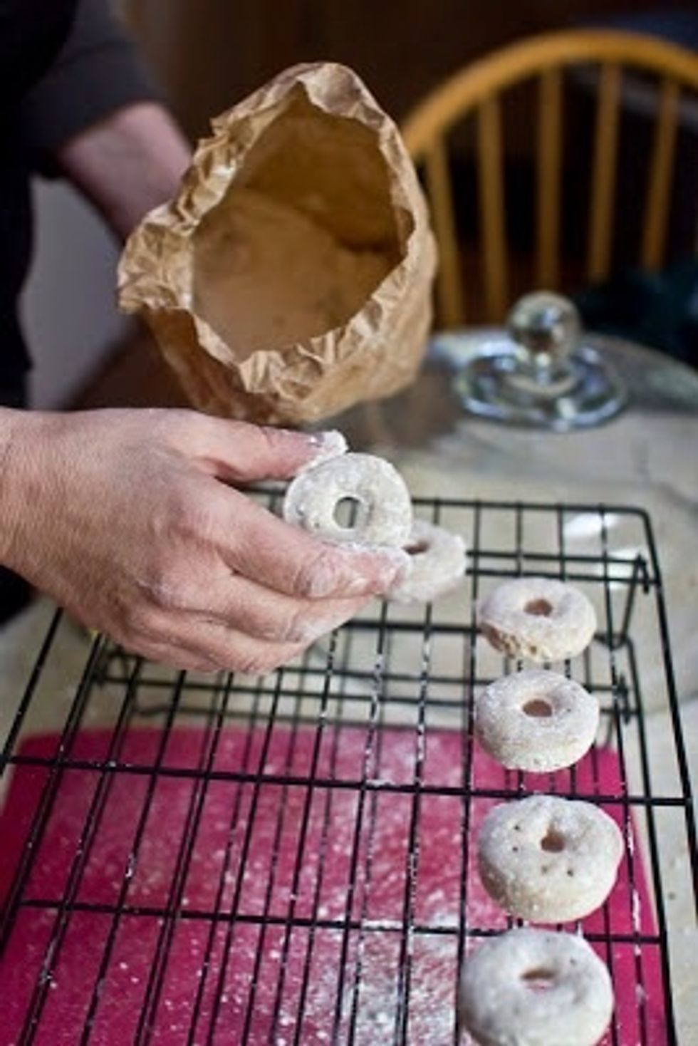 Drop the mini donuts into a bag containing the 2 cups of powdered sugar. Shake it up baby.  Put them on a wire rack to cool a bit.