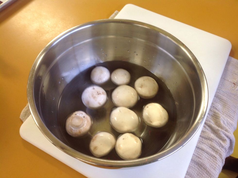 Drop the mushrooms in the COLD water. Do not let them sit in the water. Mushroom are porous vegetables which means they will soak up the water. If they soak up too much water they will become soggy.