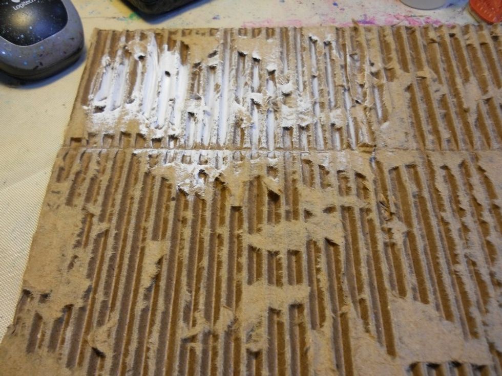 Dry brush Gesso or what craft paint onto the Cardboard.