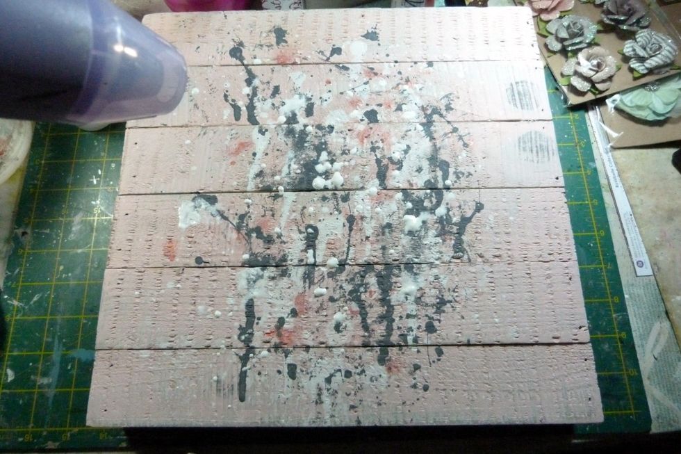 Dry, dabbing the grey paint with a piece of kitchen towel to smudge slightly and help dry it. Finish off with another splatting of gesso/ water mix. Dry.