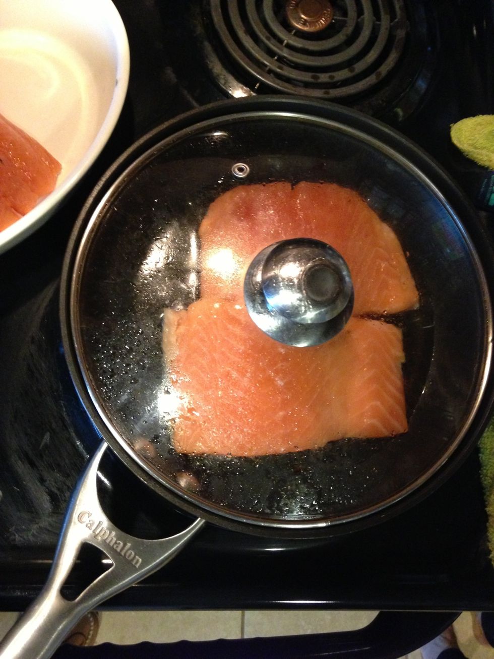 Dry fish with paper towel so it won't splash as much when frying. Fry in pan with oil on high for first 5 min then medium with lid until cooked and skin is golden