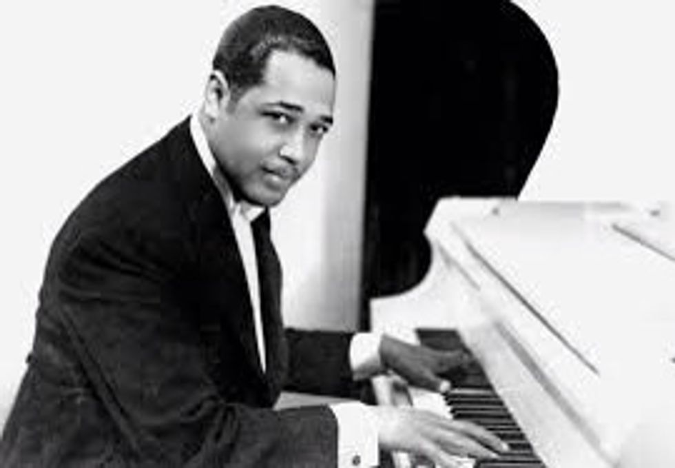 Duke Ellington va viure els anys 1899-1974. Era un compositor, director i pianista estatunidenc de jazz i en aquesta imatge surt tocant el piano.