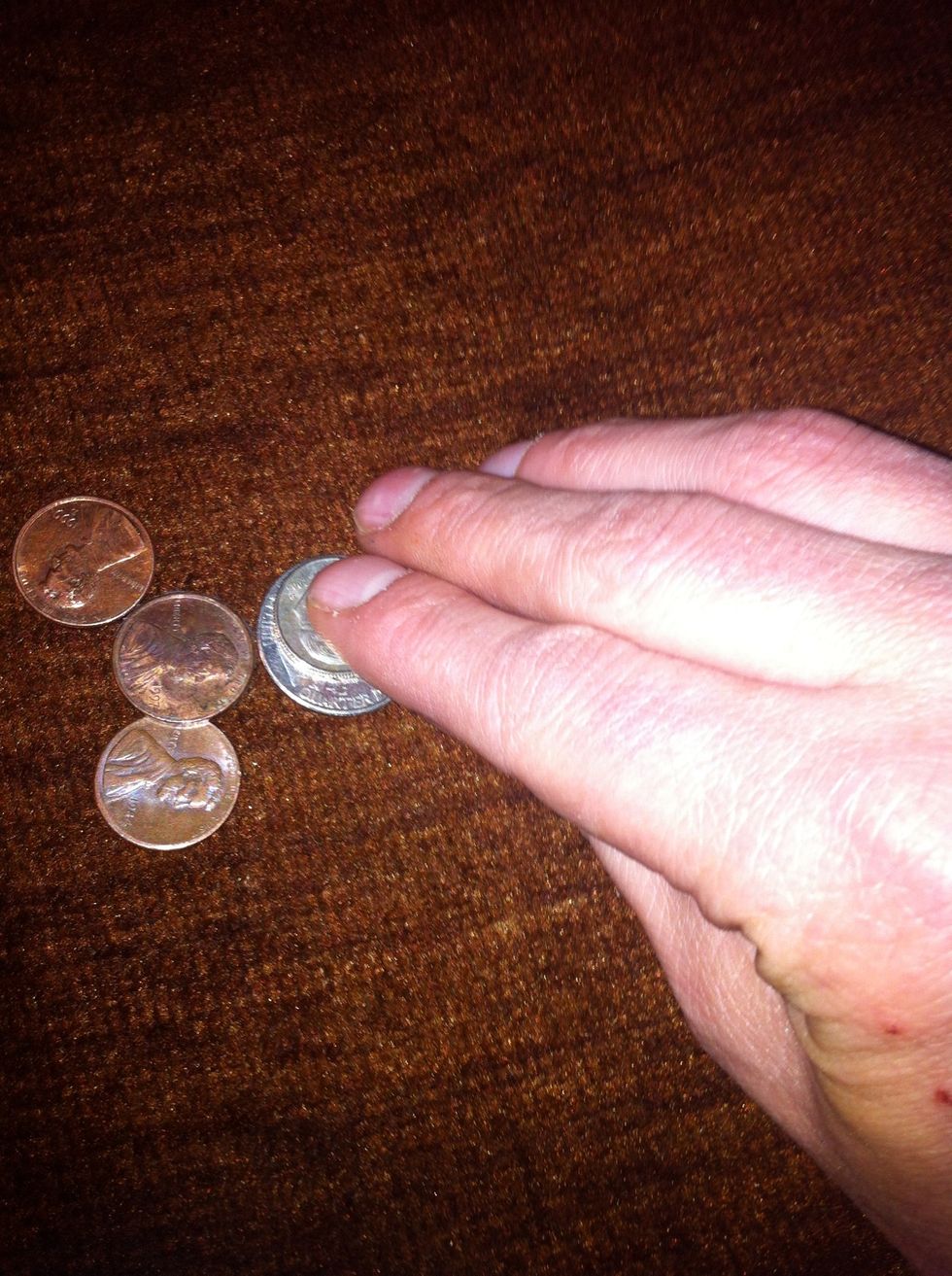 Dump a hand full of change on the table. Then pretend to pick one of them up.