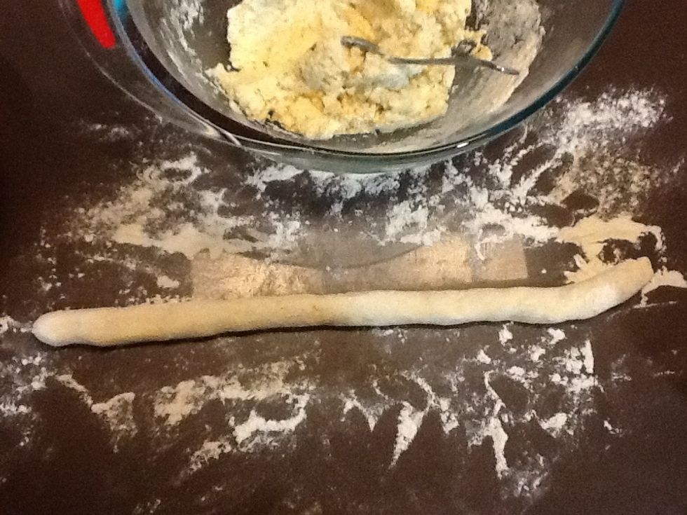 Dust the bench with flour.  Take about a quarter of the dough, and with floured hands, roll the dough into a long sausage approximately 2cm wide.