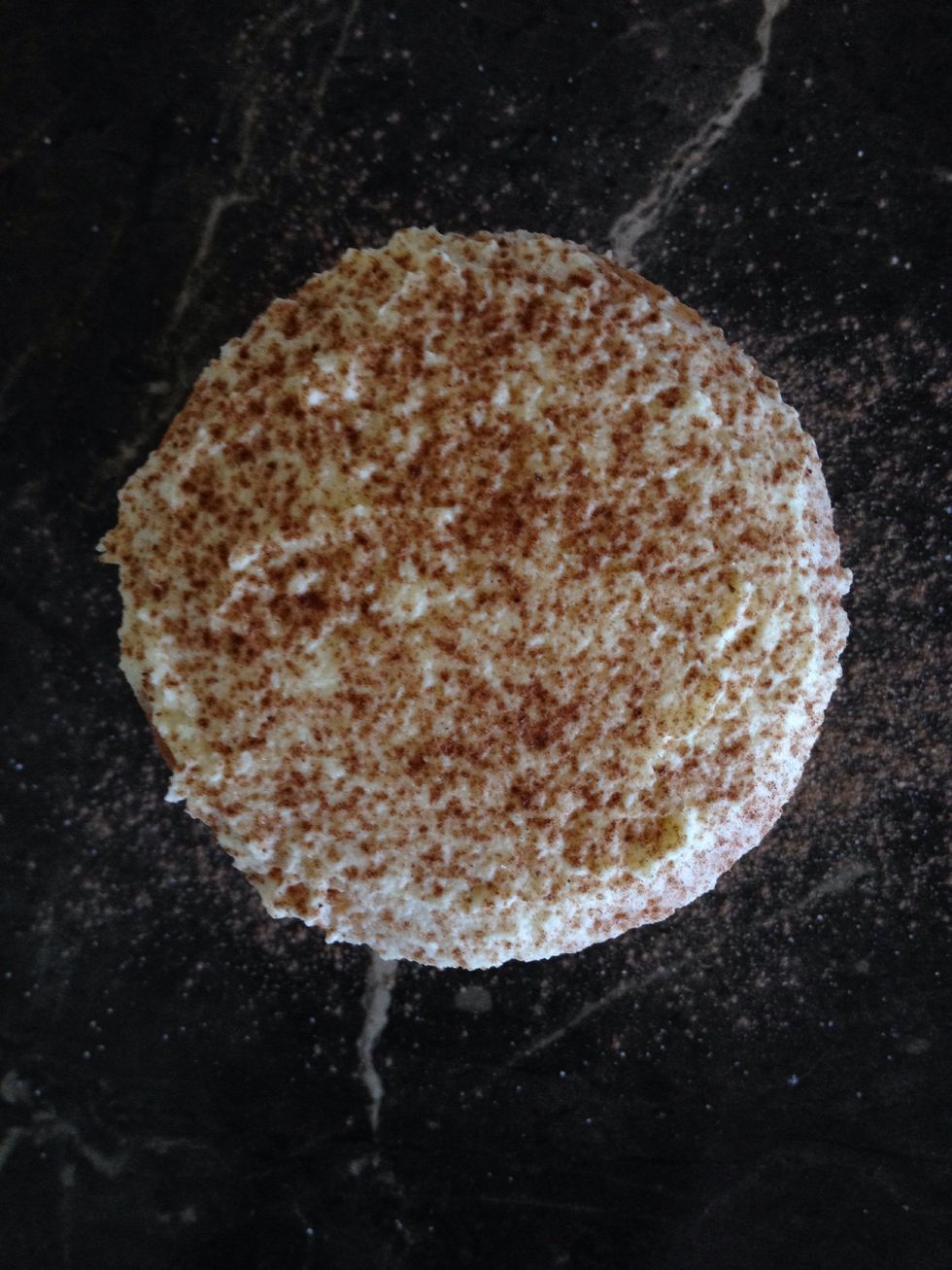 Dust two of the iced cupcakes with cocoa powder.