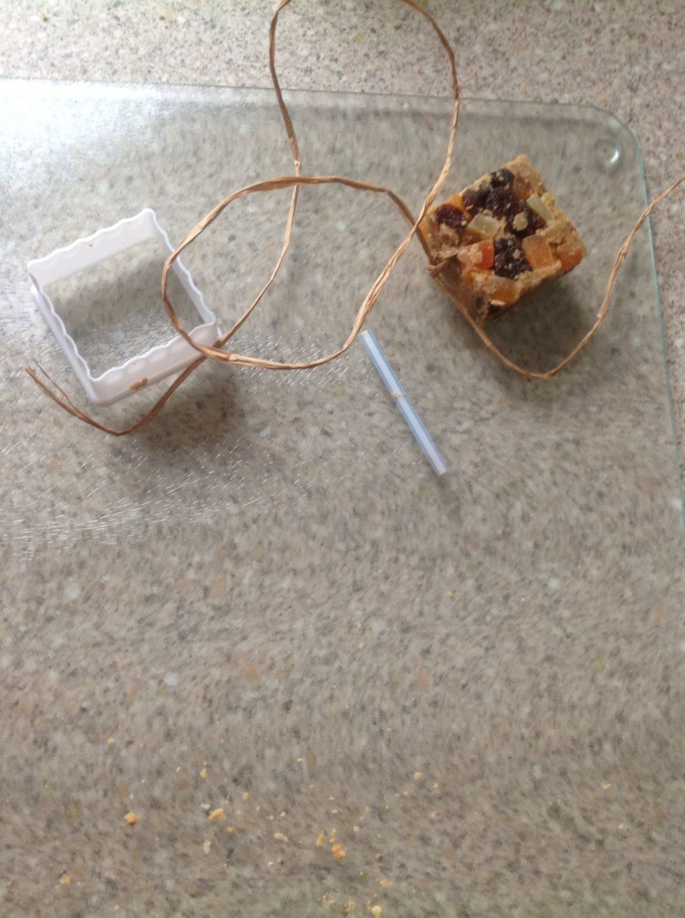 Ease the suet cakes out of the pastry cutters, remove the straws and tie on some cord, raffia, or ribbon.