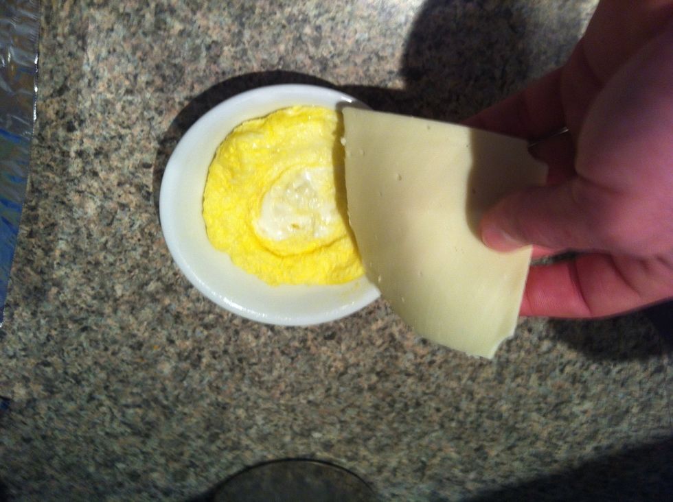 Eggs out. Put the slice of cheese or a handful of shredded on top of the egg and put the bacon in. My microwave gets set to 80% power for 35-40 seconds for the bacon.