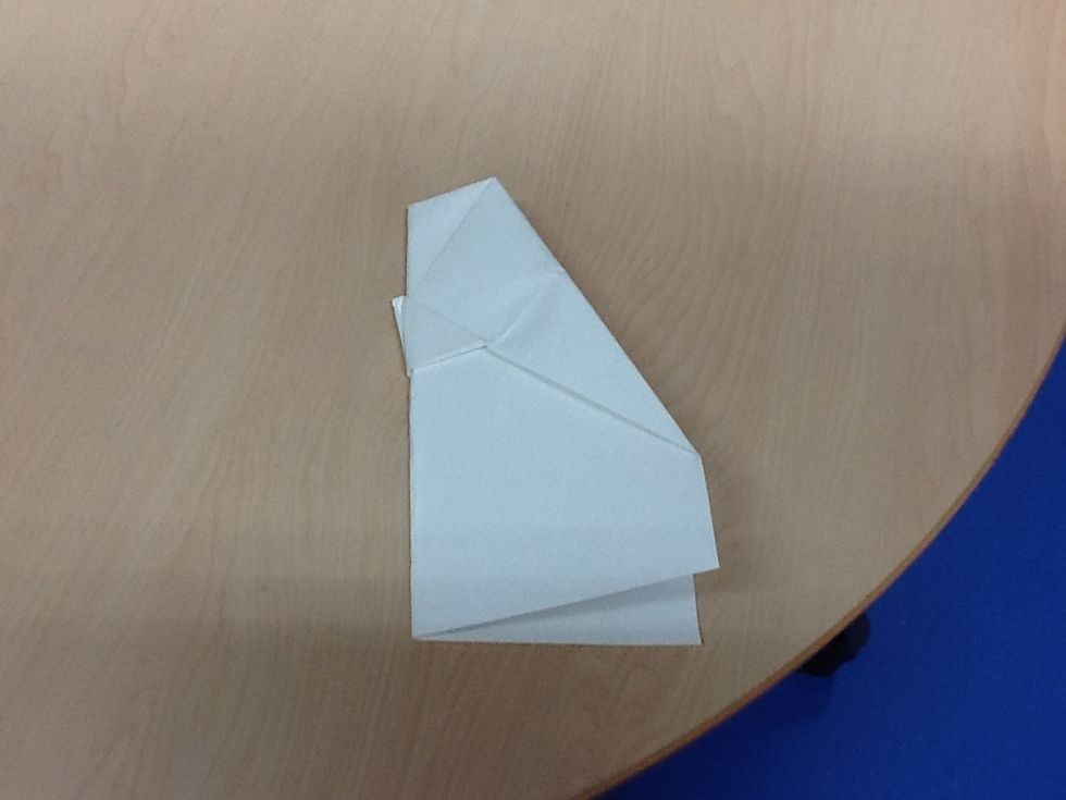 Eighth, fold it side ways along the middle line of the paper be very careful doing it.