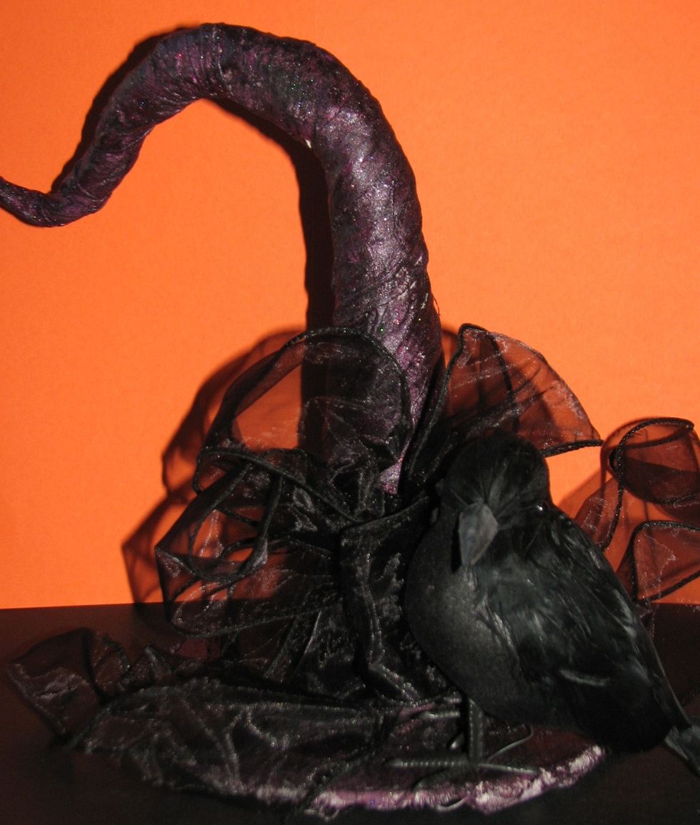 Embellish the hat to fit your decor/theme.  Here I simply added 2" wired black ribbon and a raven for a simple Halloween look.