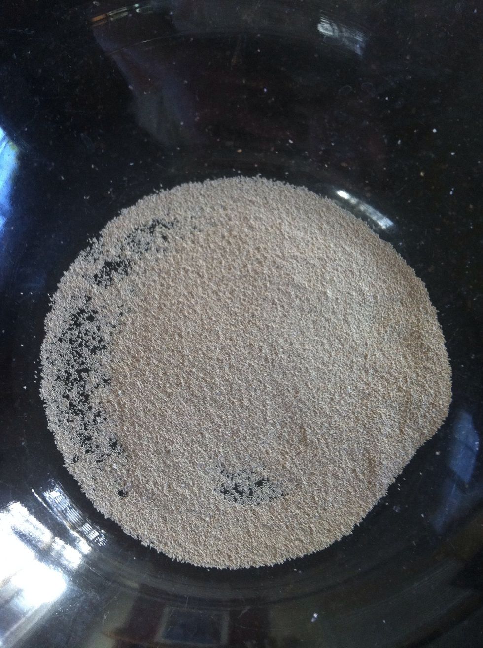 Empty 2 (1/4 oz) packets of active dry yeast into a bowl.