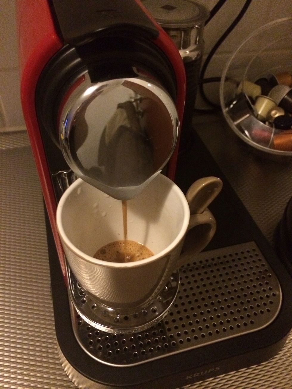 Empty the cup of the warm water and put it back in place. Press the espresso button.