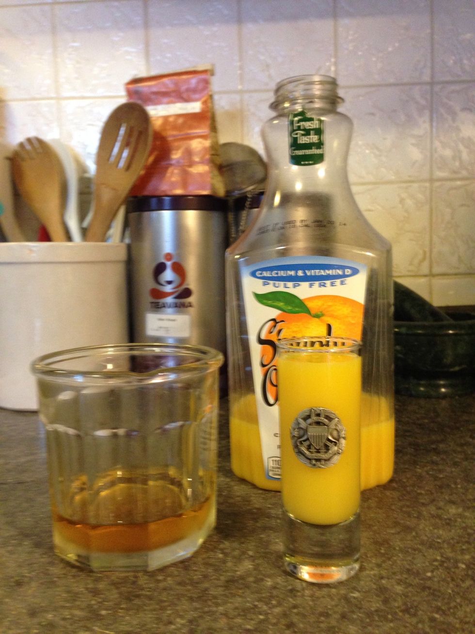 Empty the shot glass into the rocks glass and refill the shot glass with orange juice.