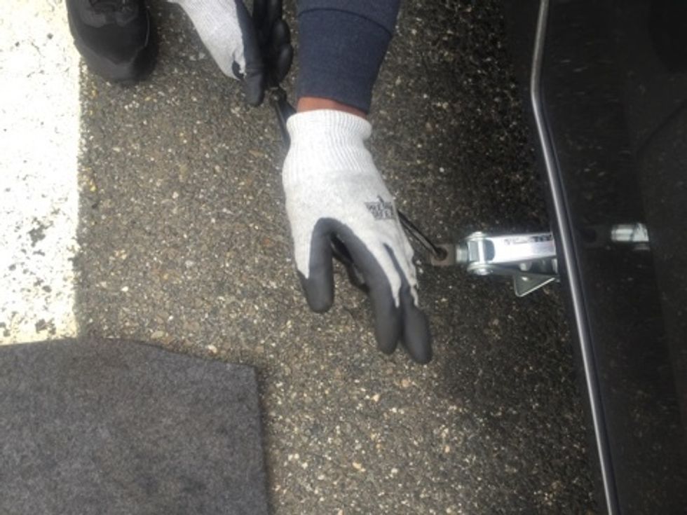 Ensuring all recently assembled parts stay together, turn lug nut wrench clockwise to raise the vehicle.