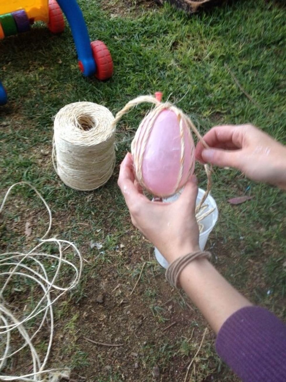Envolver la cuerda remojada en el globo, comenzando con un nudo en la parte de arriba del globo. / Wrap the wet rope around the ballon, starting with a knot at the top of the ballon.
