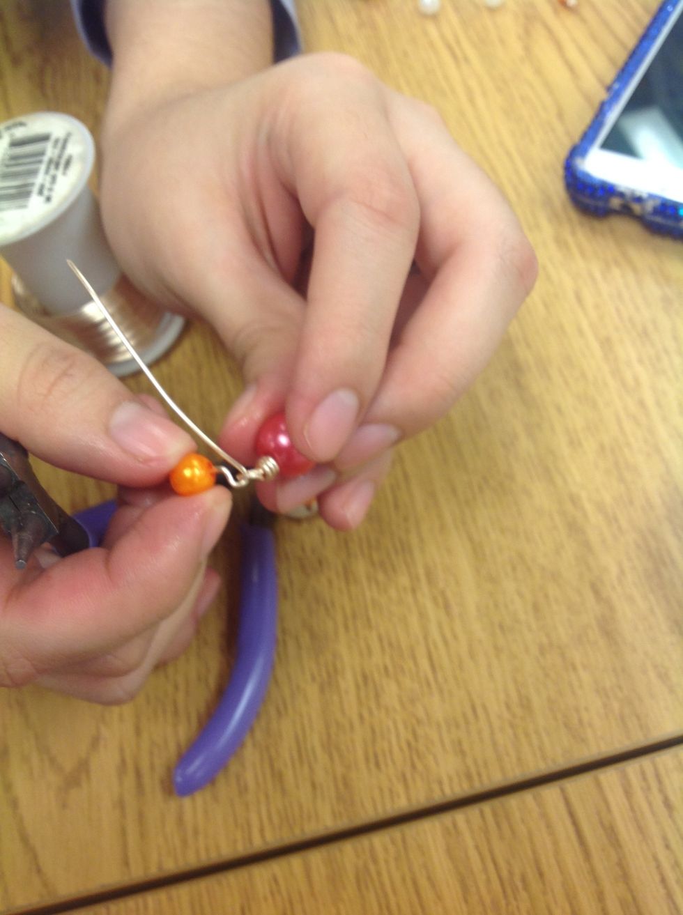 Envuelva el hilo circulo con las alicates como en paso 2 pero no lo rede. Ponga su parte de pulsera en el circulo.