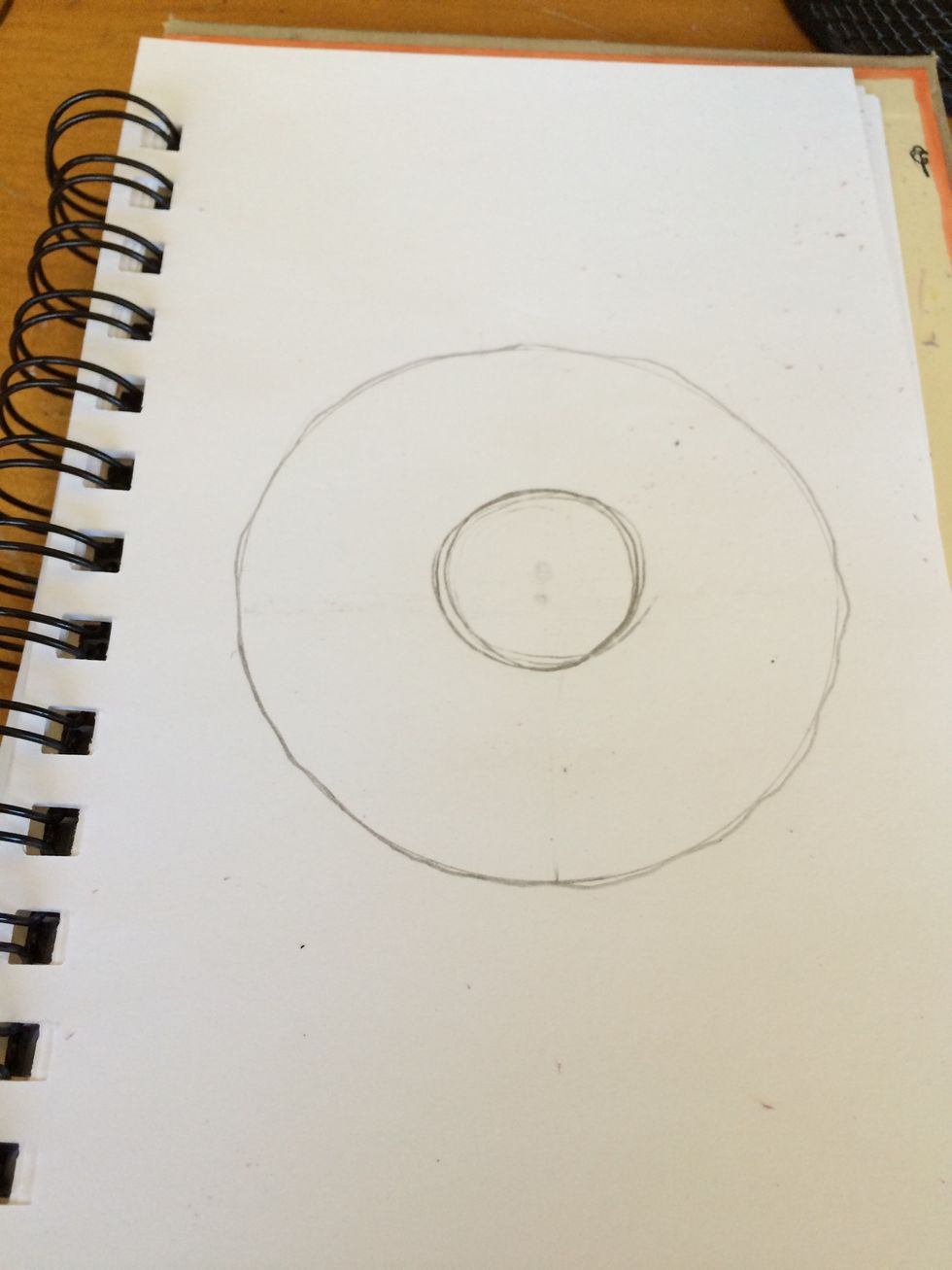 Erase center circle and add small curves to the outside of the big circle