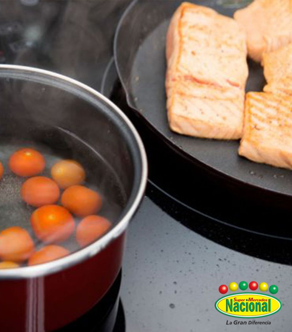 Escurre el pescado y coc\u00ednalo a la plancha con un chorrito de aceite. Pon agua a calentar en una cazuela. Cuando hierva, pon los tomates y esc\u00e1ldalos. Pela y res\u00e9rvalos.