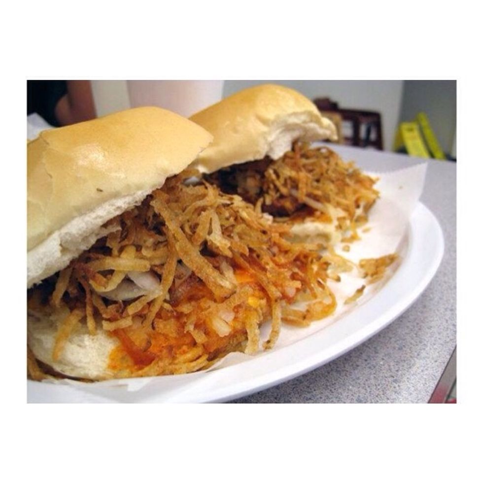 Este en un incre\u00edble frita del rey de fritas cuenta con cebollas, papas fritas mimo y carne plana en forma de hamburguesa