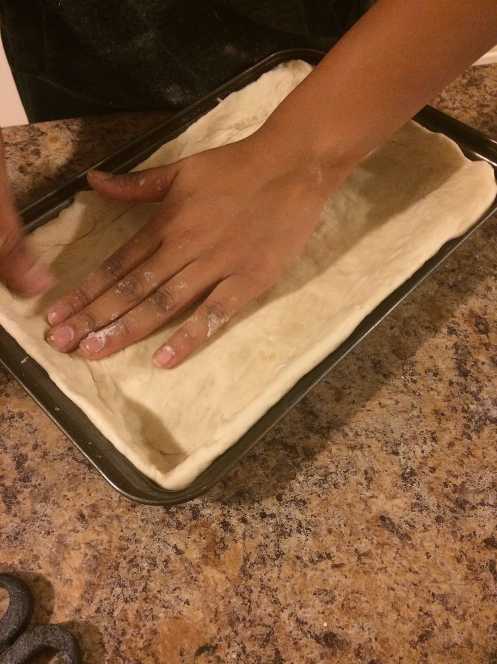 Even out the dough on the pan. Make sure you have the right amount of dough because due to the yeast it may overflow
