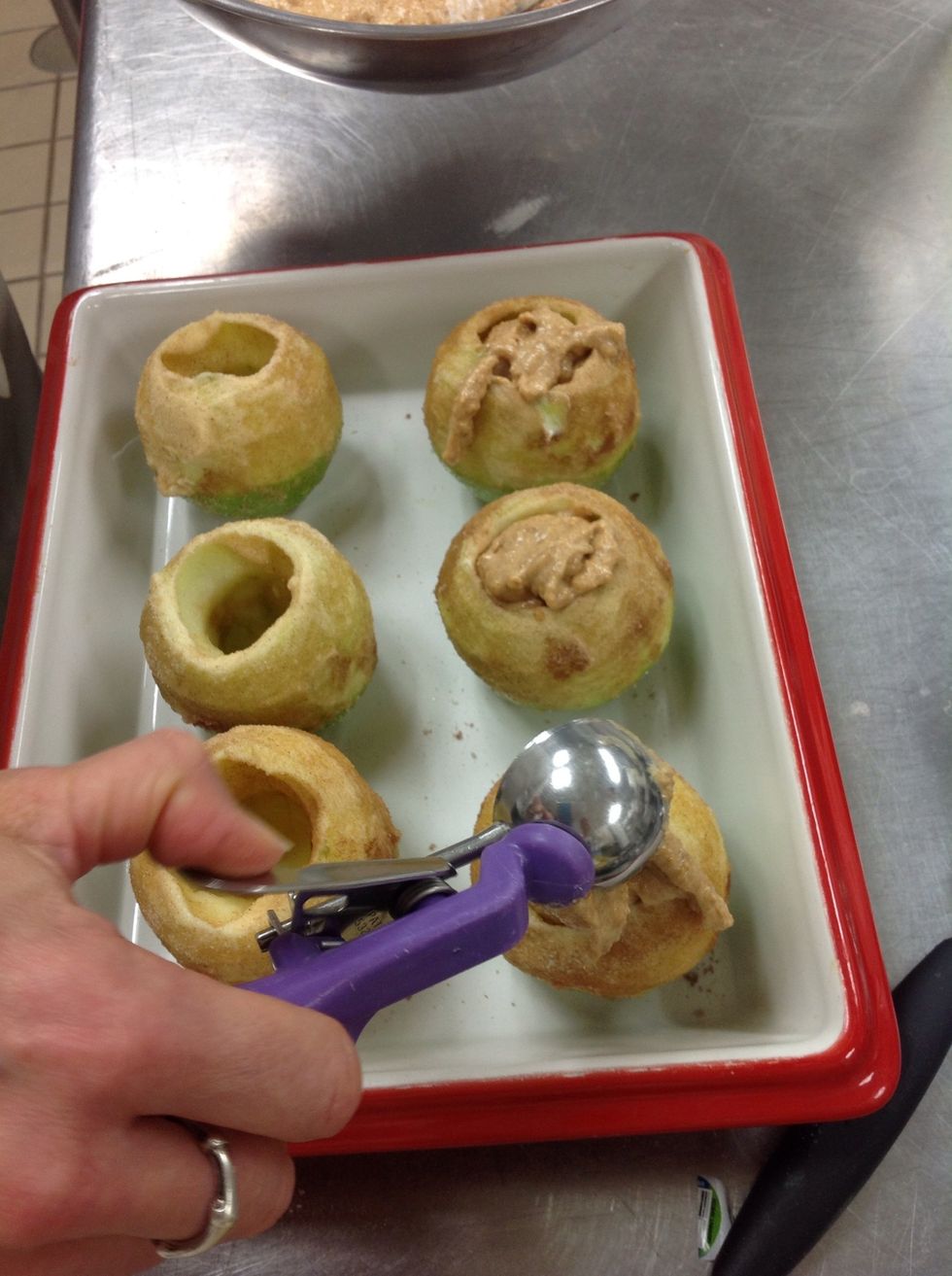 Evenly scoop cookie mixture into apples.