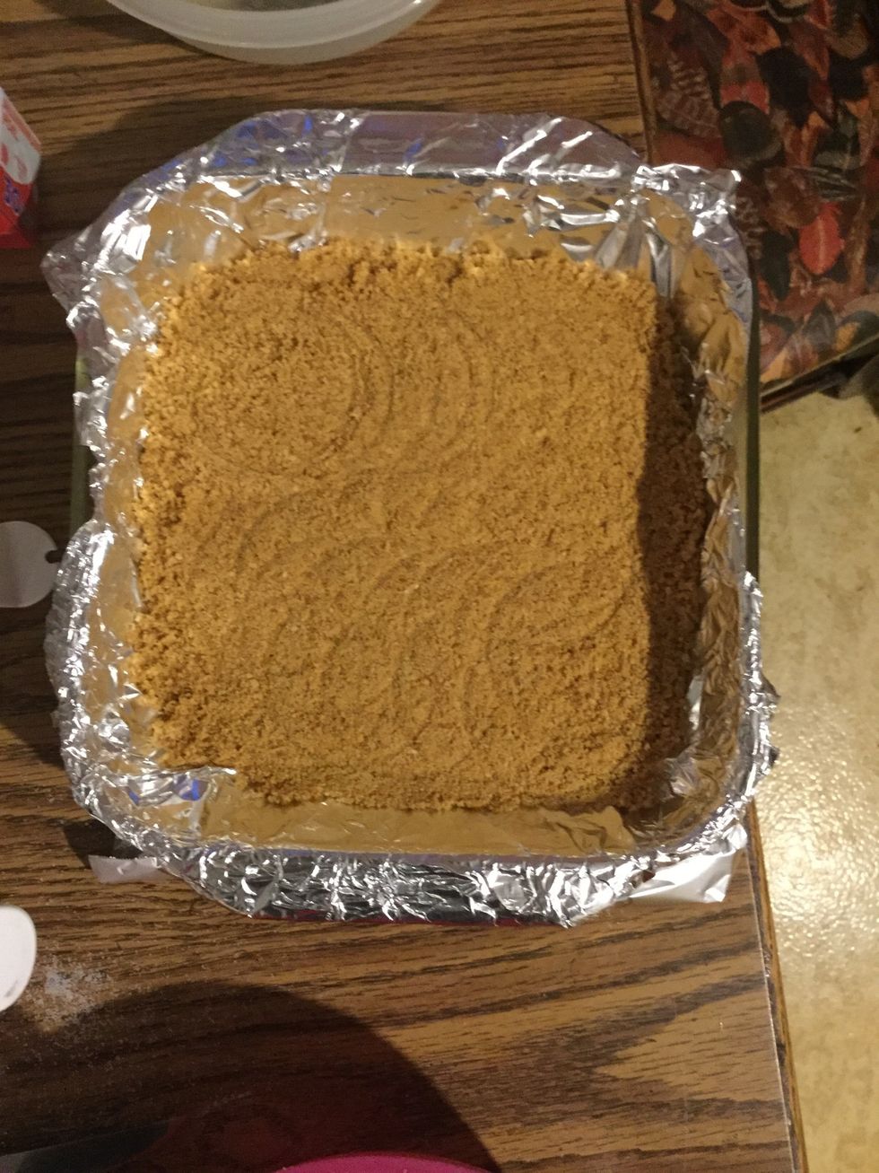 Evenly spread the graham cracker mix into your baking dish and flatten it out with the bottom of the measuring cup.