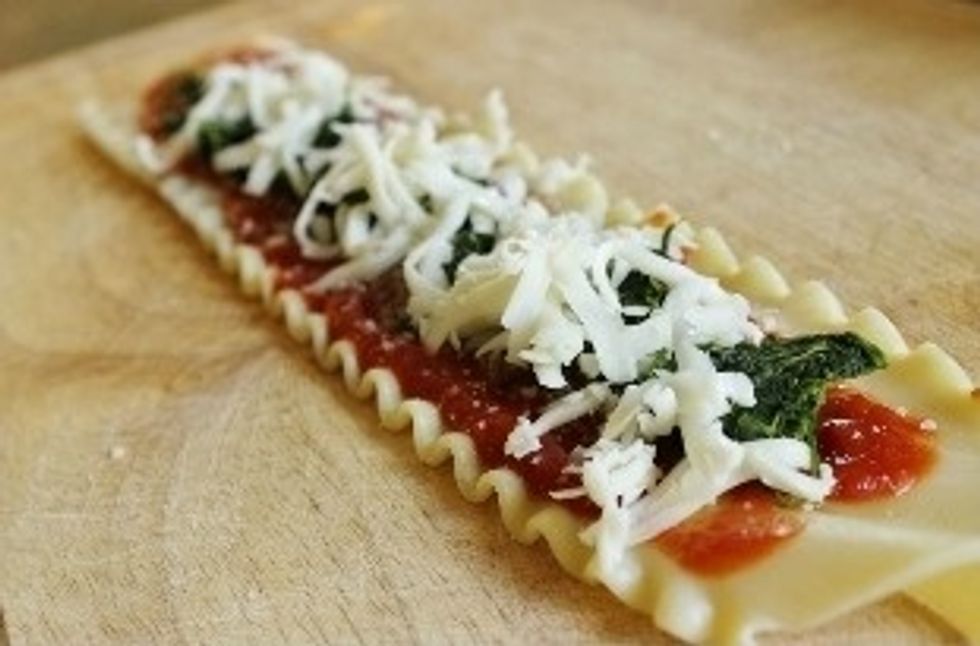 Evenly sprinkle \u00bd tbsp of grated Parmesan over sauce. Top each with equal amounts of thawed spinach and mozzarella cheese.