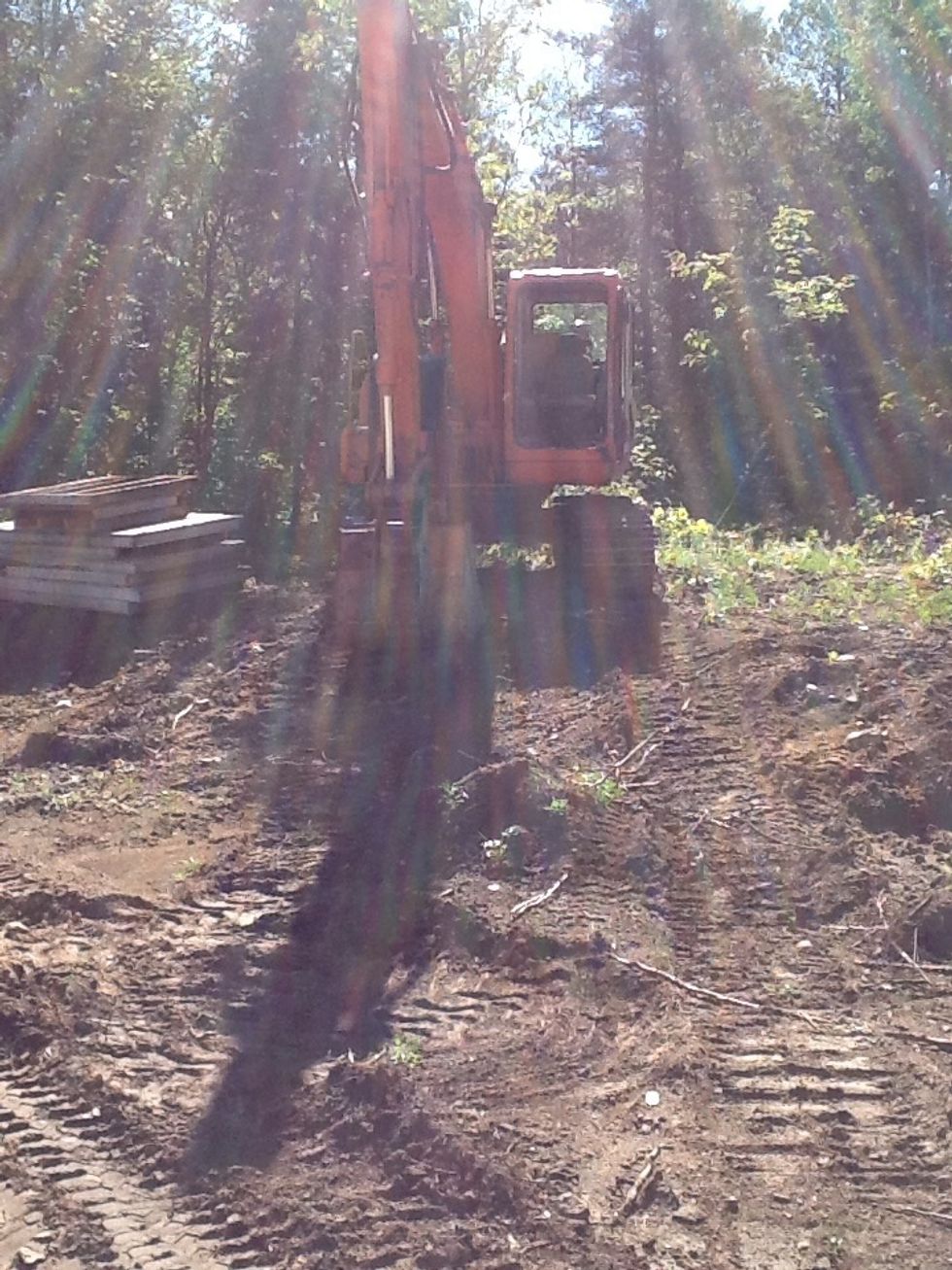 Excavator it lifts the forms around digs holes and moves fill