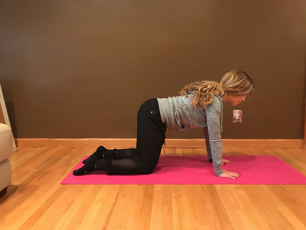 Exhale as you place your hands onto the mat and lower yourself into tabletop. Hands are under shoulders, knees are under hips and back is straight.