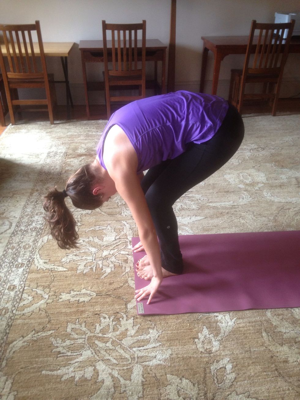 Exhale into forward fold. Tilt torso over the hips to reach the ground with hands if possible. Ribs fold against thighs, even if legs are not straight, as depicted in photograph.