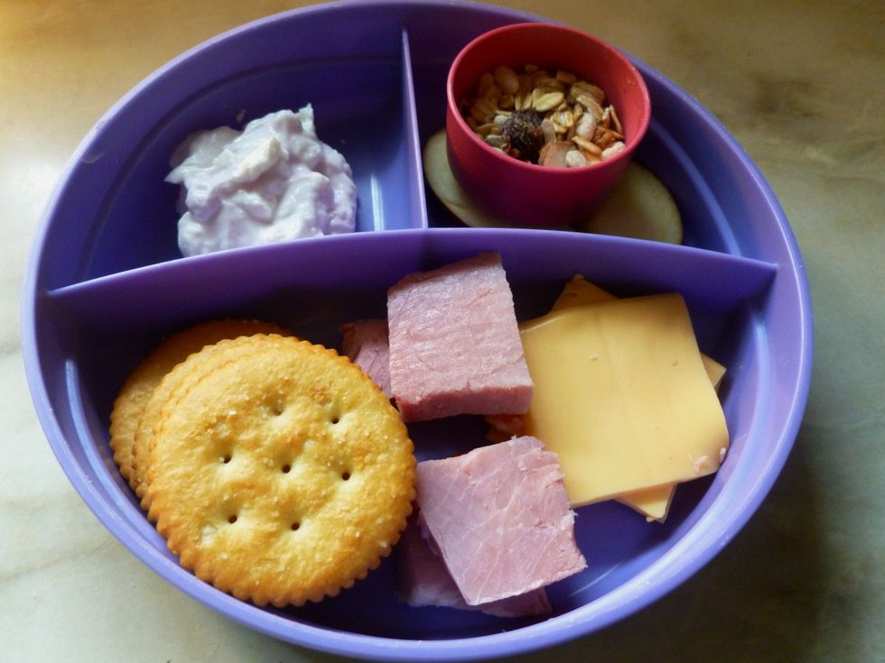 Explain to child that they stack a cheese slice and a ham slice on each cracker. Using a spoon, they will combine the Muesli with the yogurt; use as a dip for the apple slices.