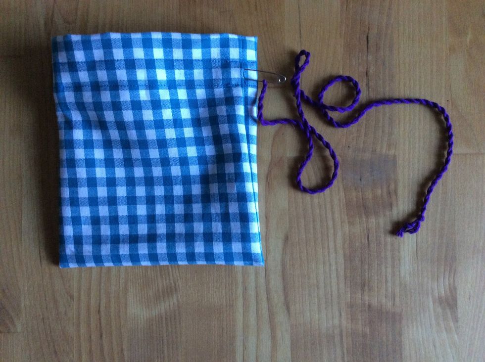 F\u00e4st en s\u00e4kerhetsn\u00e5l i \u00e4nden p\u00e5 snodden. Tr\u00e4 snodden genom kanalen. Knyt ihop \u00e4ndarna.