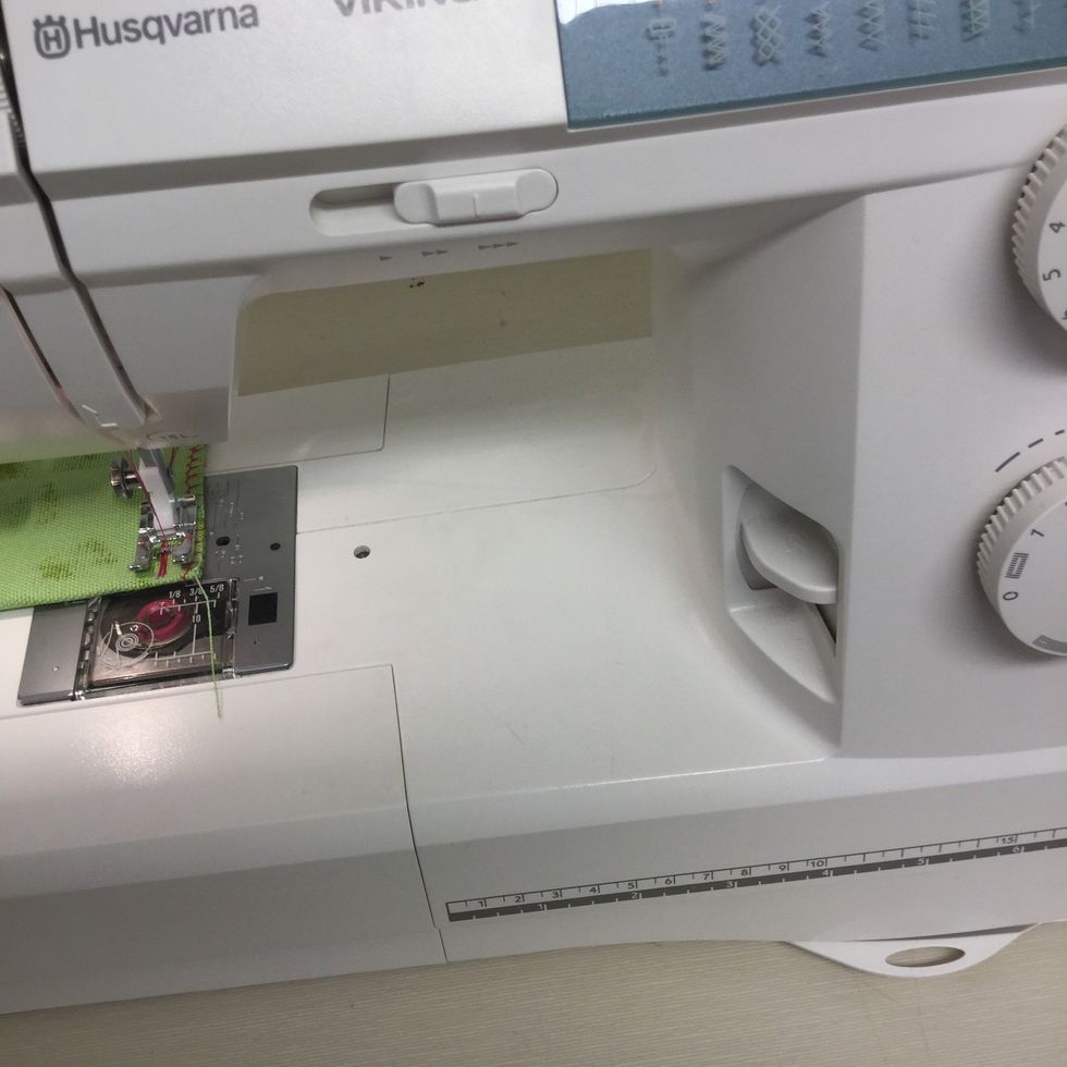 F\u00f6r att sy bak\u00e5t trycker du ner back-knappen. Den sitter till h\u00f6ger och har en b\u00f6jd pil p\u00e5 sig.