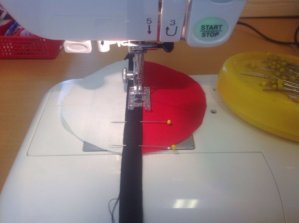 F\u00f6rs\u00f6k sy s\u00e5 l\u00e5ng ut i kanten som m\u00f6jligt. Sikta p\u00e5 att kanten p\u00e5 bandet ska l\u00f6pa i "h\u00e5let" p\u00e5 pressarfoten.