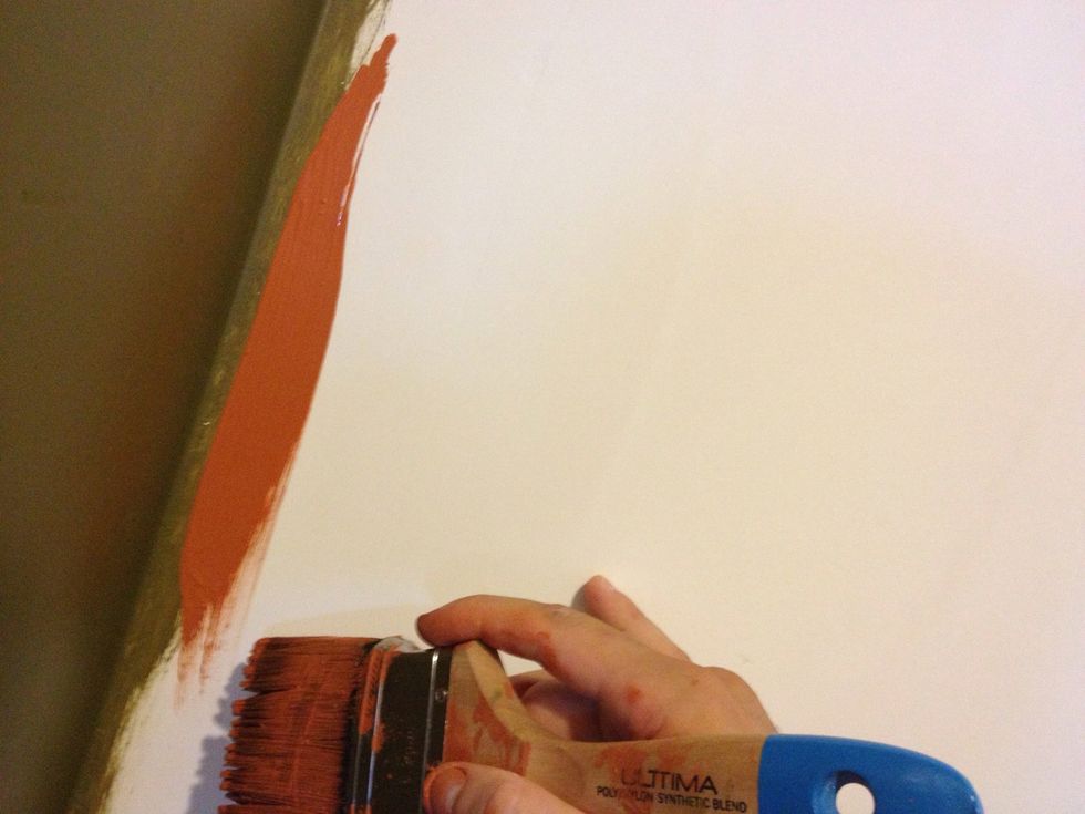 Face the side of the brush with extra paint on it towards the corner and run it down the wall near the corner. Don't worry about getting close too close to the corner just yet.