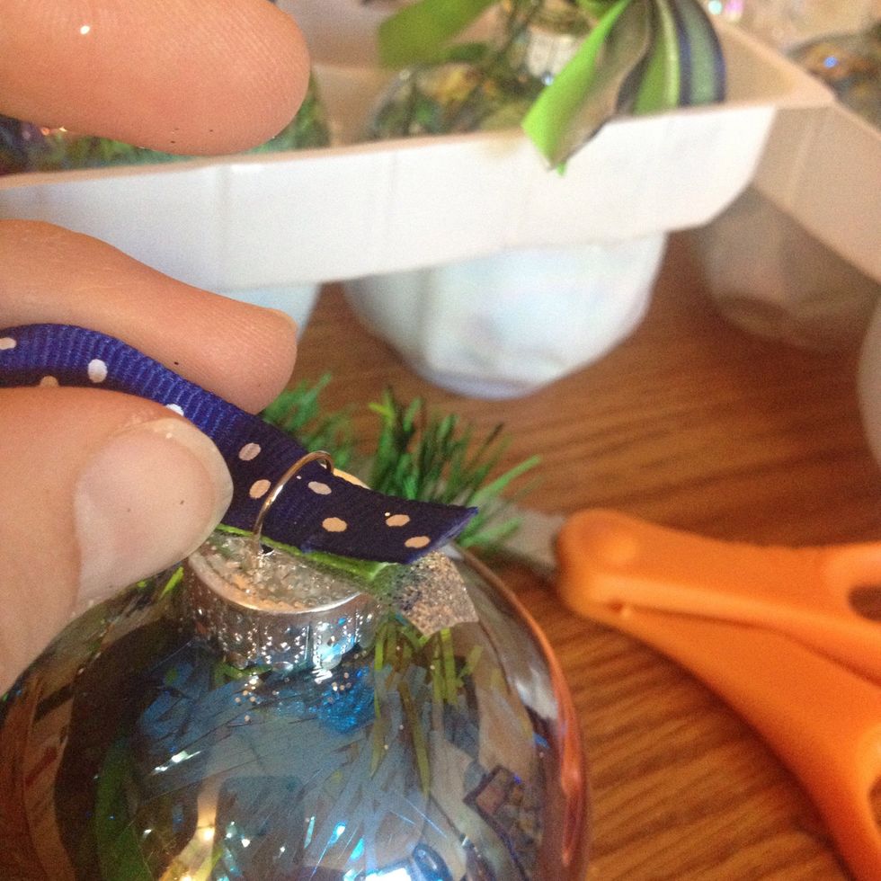 Feed the ribbon through the loop on the top of the ornament.