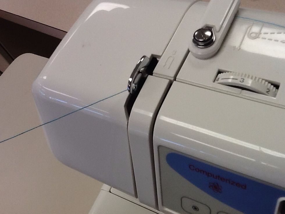 Feed the thread into the thread take up lever and back down into the same channel you just brought it up. Make sure you are feeding it in from right to left.