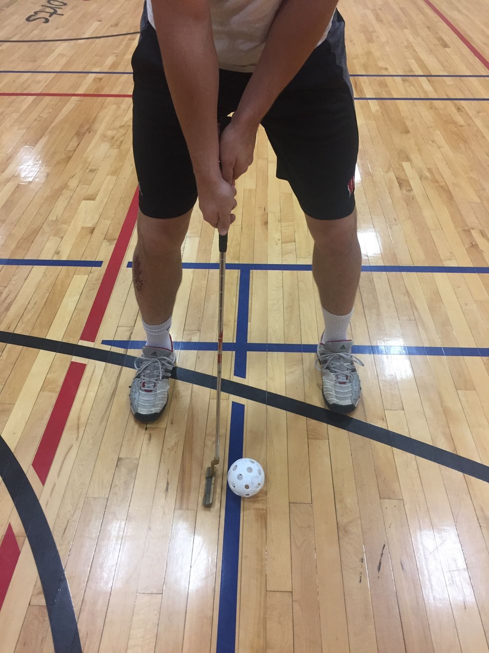 Feet and club should be 90 degrees to hole or target; ball should be set between feet; eyes over ball