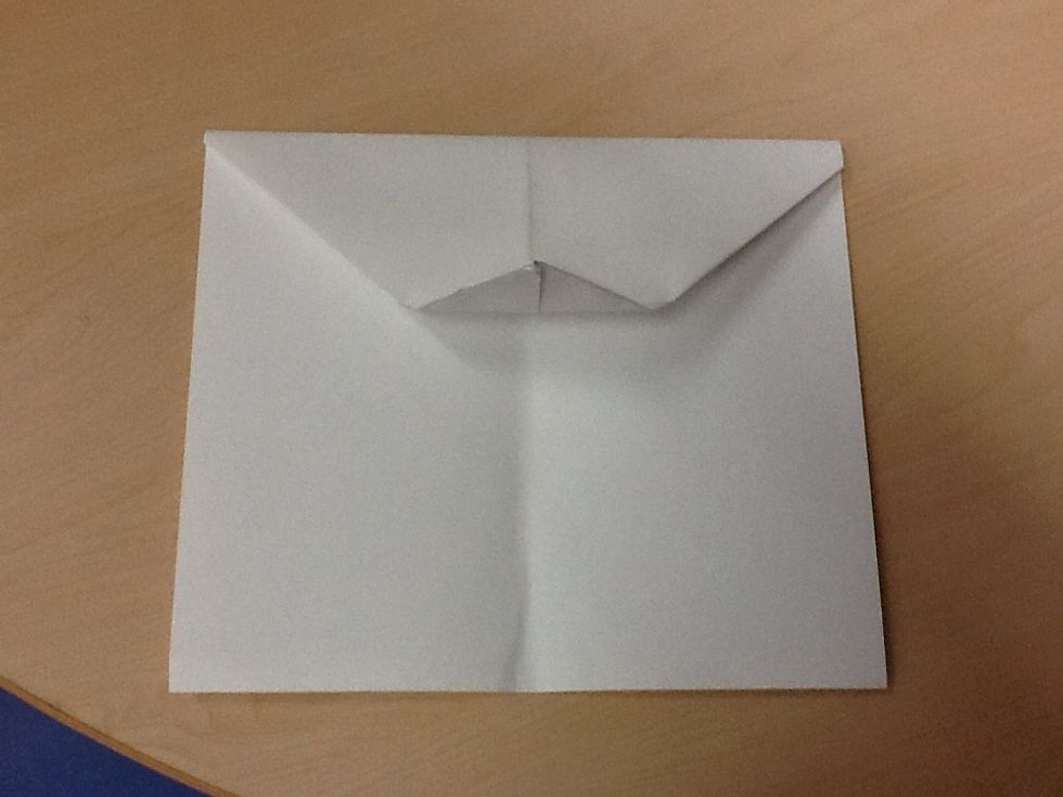 Fifth, fold the tip of the paper to the half way point then unfold it.