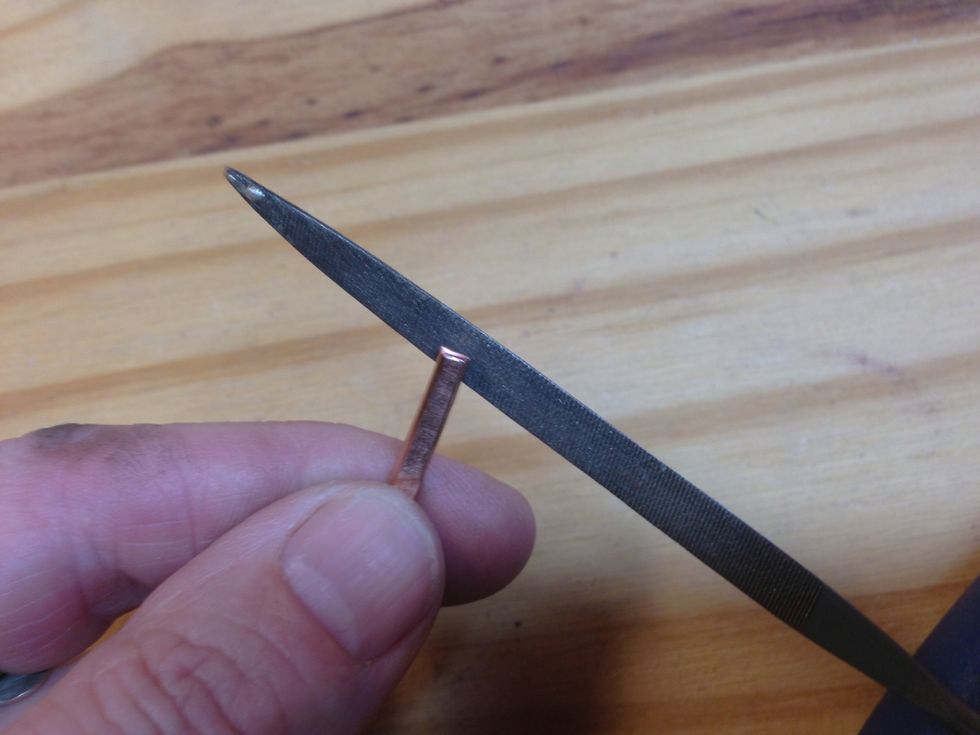 File the cut edges until they feel smooth, and file the flat edges near the ends where the jump rings will connect.