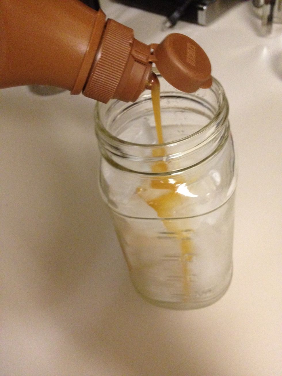 Fill a glass full of cubes of ice. Pour in as much caramel as you want, less obviously if you want less sugar. 1 to 2 pumps of caramel flavored syrup or vanilla flavored syrup as you would like.