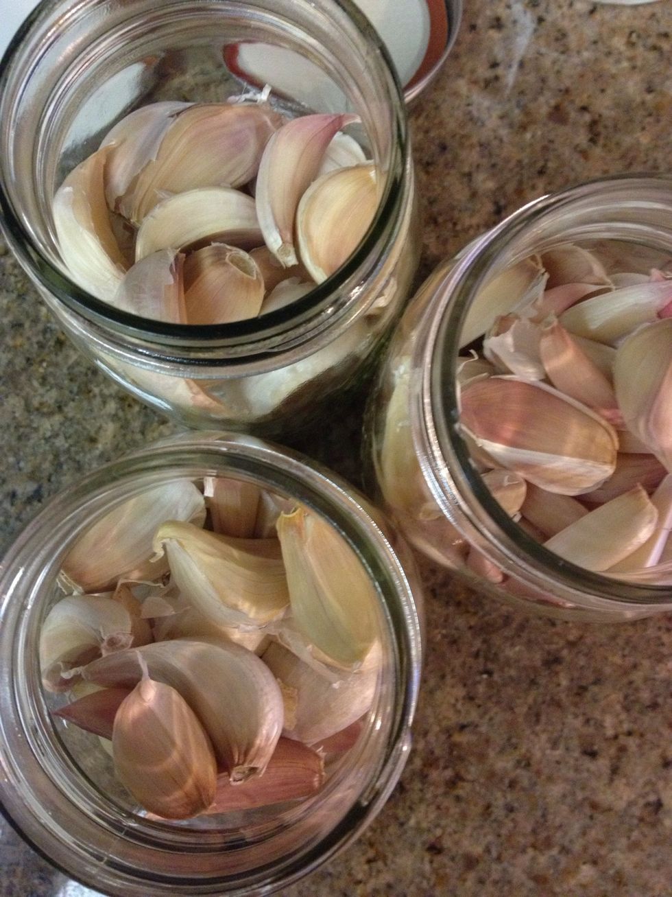 Fill a jar with unpeeled cloves. Remove the outer most skin leaving a layer still intact on the cloves.