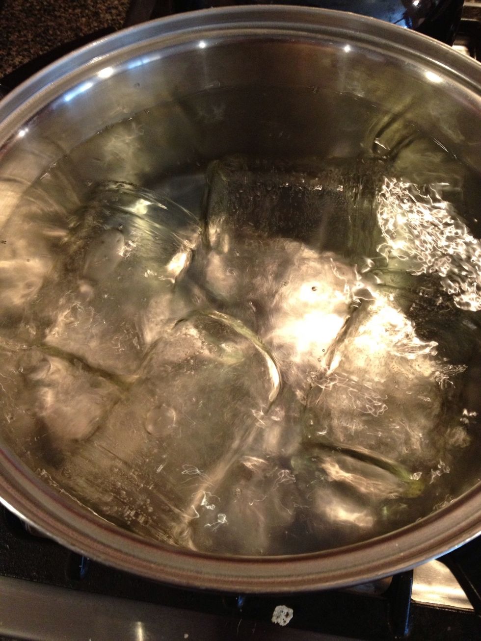 Fill a large pot with water and bring to a boil.  Place several jars, rings, or lids in the pot making sure they are completely submerged in the boiling water.