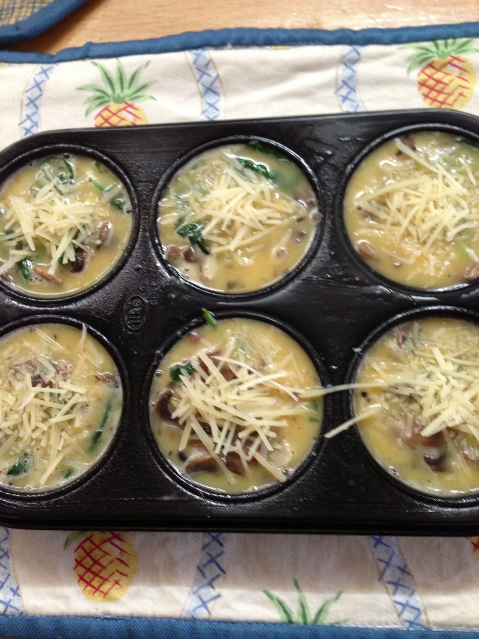 Fill cupcake pan to 2/3 (Mine looks full to the top, don't do this as they will overflow your pan once they are cooking), 5 eggs are enough for 6 cups. Sprinkle some Parmesan cheese on top.
